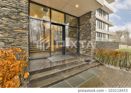the outside of a modern house with stone walls and glass doors that look like it's going to fall the outside of a modern house with stone walls and glass doors that look like it's going to fall 103218455