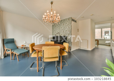a dining room with blue flooring and wallpapers on the walls, including a large chandele a dining room with blue flooring and wallpapers on the walls, including a large chandele 103218645