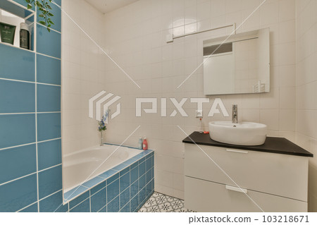 a bathroom with blue and white tiles on the walls, sink and mirror in the corner of the bathtub a bathroom with blue and white tiles on the walls, sink and mirror in the corner of the bathtub 103218671
