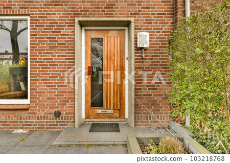 a brick building with a wooden door and planters on the sidewalk in front of the entrance to the house 103218768