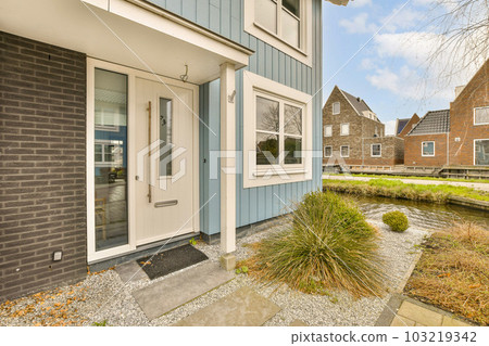 an outside view of a house in the country side with blue sidings and white trim on the exterior walls 103219342