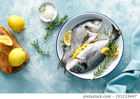 Fresh raw dorado fish cooking with lemon and rosemary. Sea bream, dorado. Seafood, healthy food. Top view 103219447