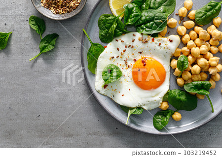 Egg fried, boiled chickpea and fresh spinach for healthy breakfast, top view Egg fried, boiled chickpea and fresh spinach for healthy breakfast, top view 103219452