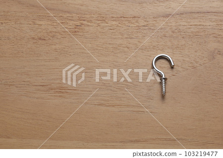 Screws with hooks photographed on a wooden table Screws with hooks photographed on a wooden table 103219477