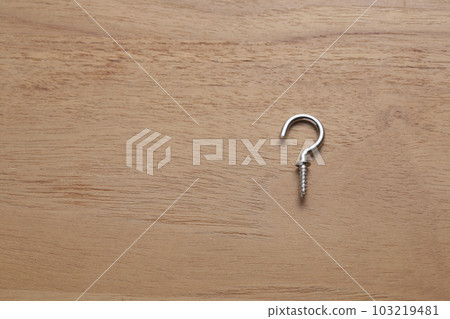 Screws with hooks photographed on a wooden table 103219481