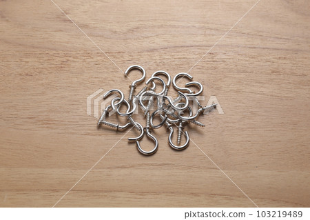 Screws with hooks photographed on a wooden table Screws with hooks photographed on a wooden table 103219489