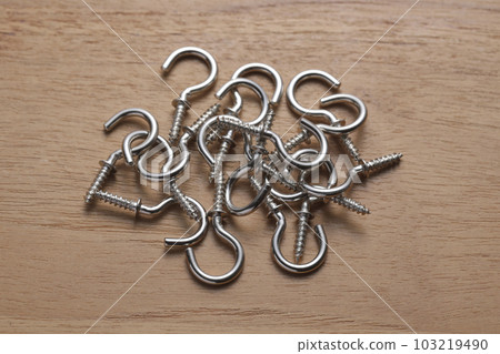 Screws with hooks photographed on a wooden table 103219490