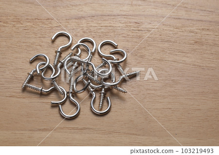 Screws with hooks photographed on a wooden table Screws with hooks photographed on a wooden table 103219493