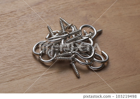 Screws with hooks photographed on a wooden table Screws with hooks photographed on a wooden table 103219498