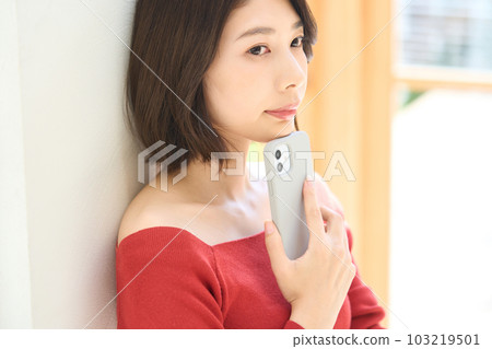 便衣的年輕女人，客廳，智能手機 103219501