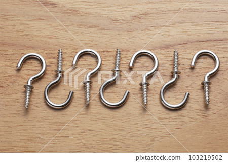 Screws with hooks photographed on a wooden table Screws with hooks photographed on a wooden table 103219502
