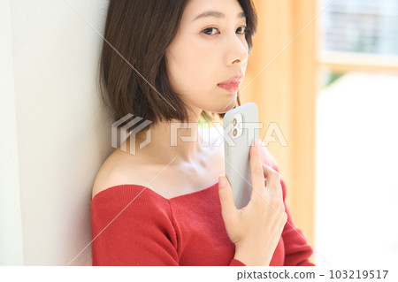 便衣的年輕女人，客廳，智能手機 103219517
