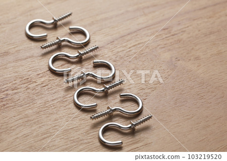 Screws with hooks photographed on a wooden table 103219520