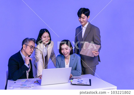 Asian Korean senior, middle aged and young male and female colleagues models in business attire, neon purple studio background, meeting while looking at a laptop Asian Korean senior, middle aged and young male and female colleagues models in business attire, neon purple studio background, meeting while looking at a laptop 103221802
