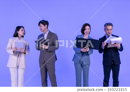 Asian Korean senior, middle aged and young male and female colleagues models in business attire, neon purple studio background, looking at the tablet and the documents Asian Korean senior, middle aged and young male and female colleagues models in business attire, neon purple studio background, looking at the tablet and the documents 103221815