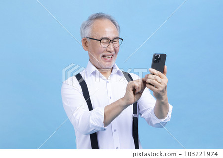 active young senior Korean Asian male looking at smartphone active young senior Korean Asian male looking at smartphone 103221974