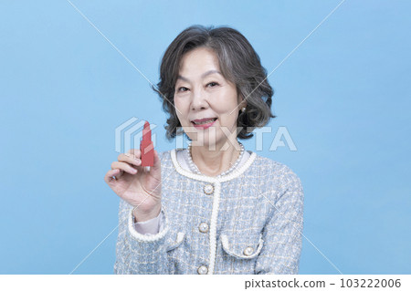 active young senior Korean Asian woman holding lipstick 103222006