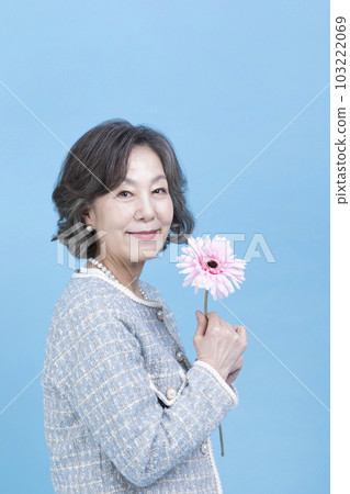 active young senior Korean Asian woman holding flowers 103222069