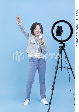 singing active young senior Korean Asian woman with smartphone, mobile karaoke concept singing active young senior Korean Asian woman with smartphone, mobile karaoke concept 103222136