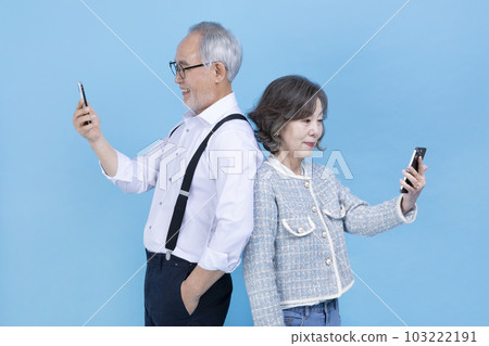 active young senior Korean Asian couple looking at each other's smartphone active young senior Korean Asian couple looking at each other's smartphone 103222191