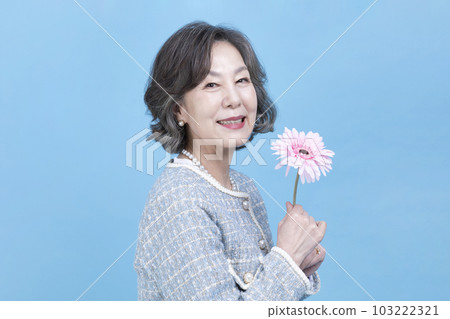 active young senior Korean Asian woman holding flowers 103222321