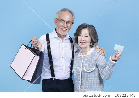active young senior Korean Asian couple holding shopping bags and credit card active young senior Korean Asian couple holding shopping bags and credit card 103222445