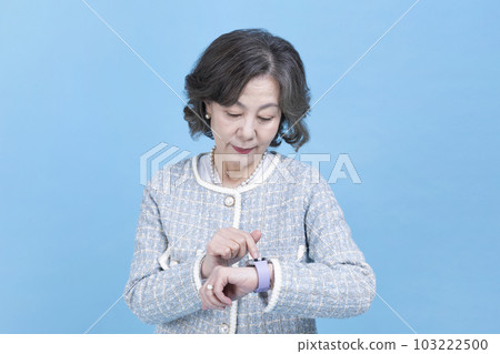 active young senior Korean Asian woman using smart watch 103222500