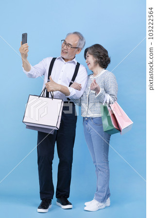 active young senior Korean Asian couple holding shopping bags and smartphone 103222564