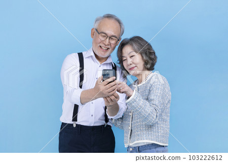 active young senior Korean Asian couple looking at smartphone 103222612