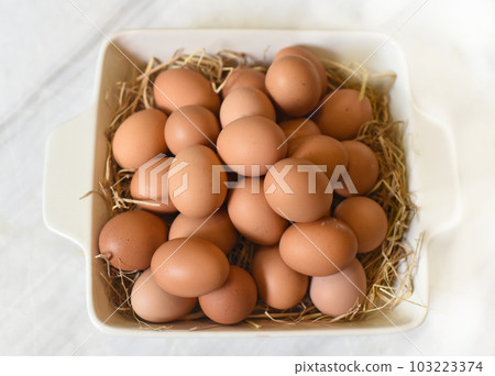 Pile of eggs on straw in a pan closeup 103223374