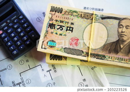 一張 10,000 日元的鈔票和一個放在相關圖表上的計算器，繼承的圖像 103223526