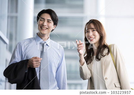 Men and women of businessmen who check the time and destination at the airport, business trip, trip, etc. Men and women of businessmen who check the time and destination at the airport, business trip, trip, etc. 103223937