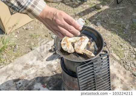 [Sprinkle outdoor spices while grilling chicken wings with embers] 103224211