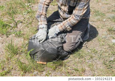 [Auto camping on the Nakatsugawa riverbed, folding a tent and putting it in a bag] 103224223