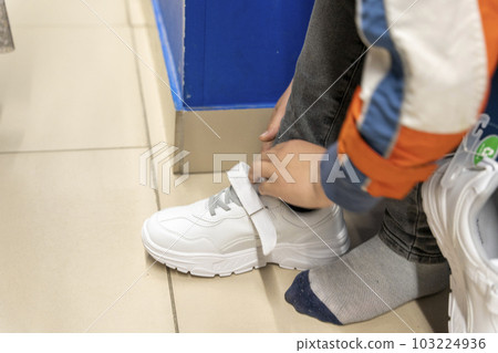 fitting new fashionable sneakers in a shoe store. Buying new shoes 103224936
