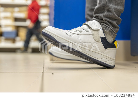 fitting new fashionable sneakers in a shoe store. Buying new shoes fitting new fashionable sneakers in a shoe store. Buying new shoes 103224984