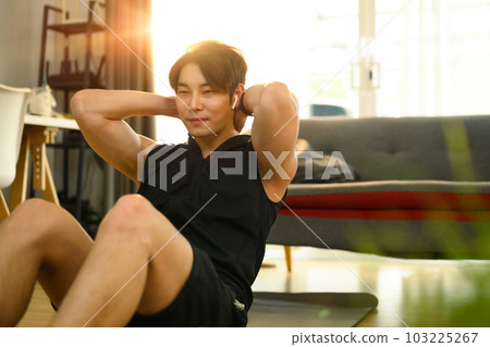 Strong asian man wearing sporty clothes doing sit up exercise during home workout. Sport, fitness and healthy lifestyle 103225267
