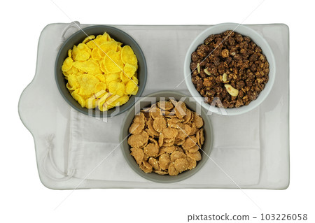 Variety of breakfast cereals and muesli in bowls isolated on white background. Fast food. Top view. Space for text. 103226058