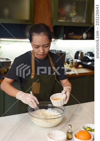Young Vietnamese woman mixing   dough for a cake 103226643