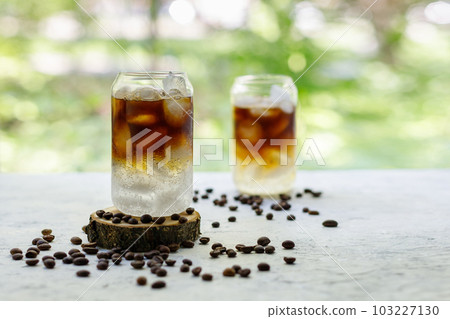 Cold black coffee with tonic and ice in glass. Summer drink on nature background 103227130