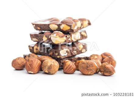Broken chocolate bars with nuts isolated on white background. Broken chocolate bars with nuts isolated on white background. 103228181