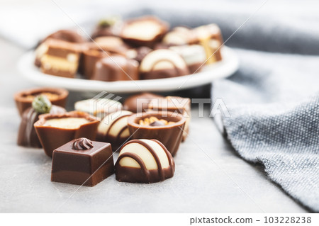 Sweet chocolate pralines. Tasty chocolate truffles on kitchen table. Sweet chocolate pralines. Tasty chocolate truffles on kitchen table. 103228238