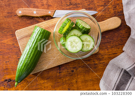 Sliced fresh green cucumber in bowl. Top view. Sliced fresh green cucumber in bowl. Top view. 103228300