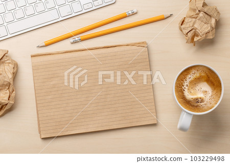 Top view of blank notepad, keyboard, coffee and crumpled papers Top view of blank notepad, keyboard, coffee and crumpled papers 103229498