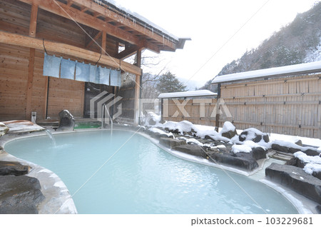 An open-air bath at a ryokan covered in snow | A cloudy hot spring 103229681