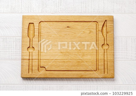 Wooden cutting board on kitchen table 103229925