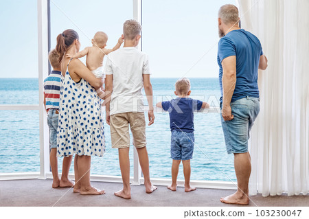 Parents and boys siblings enjoy spending together summer holidays on seaside. Father and mother take sons on holidays near azure sea Parents and boys siblings enjoy spending together summer holidays on seaside. Father and mother take sons on holidays near azure sea 103230047