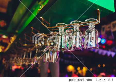 different glasses hanging over the bar. Soft focus. different glasses hanging over the bar. Soft focus. 103232401