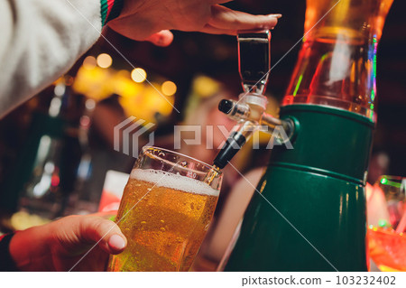 Barman pours beer into glasses for its tasting. Barman pours beer into glasses for its tasting. 103232402