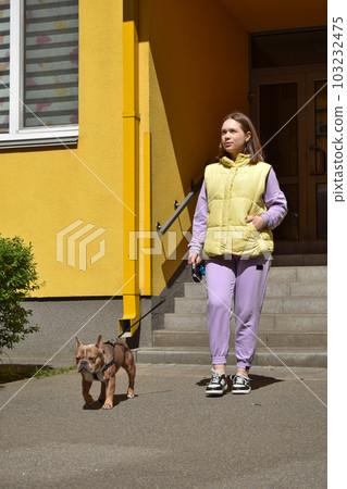 Vertical shot female pet owner going out home walking dog outdoors Vertical shot female pet owner going out home walking dog outdoors 103232475